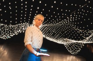Woman places hand beneach sensor at Rafael Lozano-Hemmer's Pulse Topology lighting installation at Miami Art Week 2022
