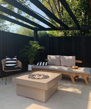 Gas fire pit in covered seating area painted black
