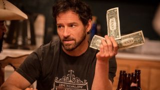 Ian Bohen as Ryan holding up three one dollar bills on Yellowstone.