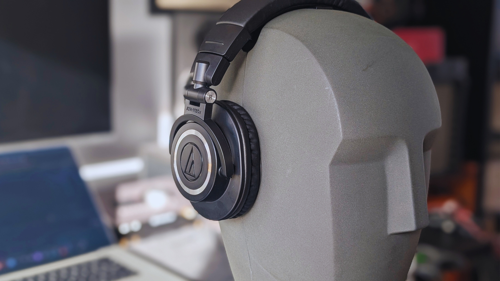 Close up of a pair of Audio-Technica ATH-M50x studio headphones on a Neumann dummy head