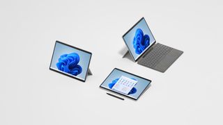 A photograph of three Microsoft Surface Pro 8 units showing different use modes