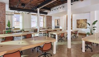 Open plan office space with exposed ceiling and large windows
