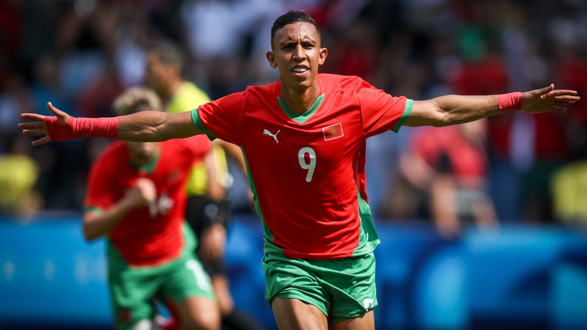 Soufiane Rahimi, of the Morocco team, celebrates a goal at the 2024 Paris Olympic Games in his team&#039;s red shirt and green shorts kit.