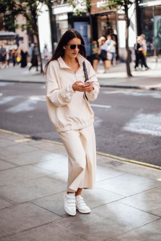 woman wears an all-white outfit with white velcro sneakers