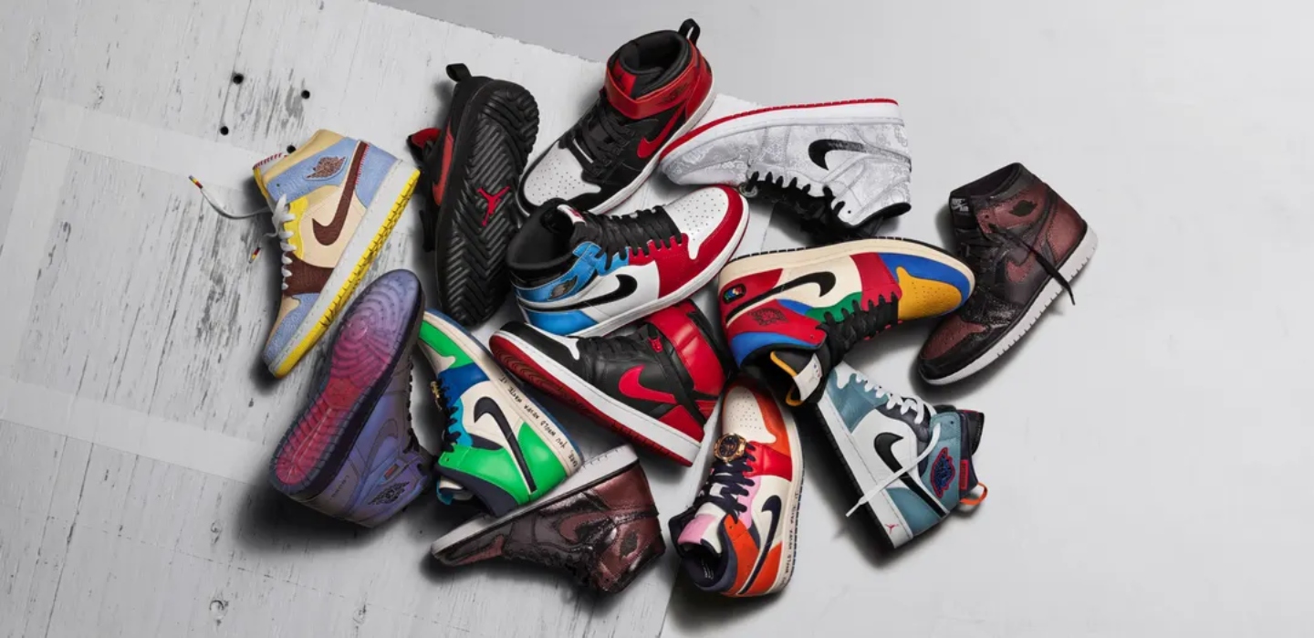 Lots of different Nike shoes of different colours on a grey background
