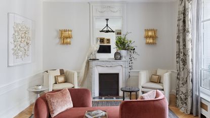 living room with pink tete a tete sofa and fireplace with two white armchairs