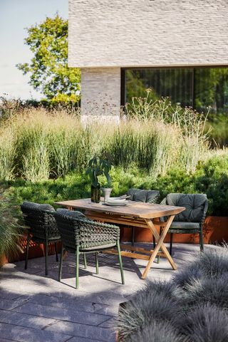 garden divider ideas: grasses and corten steel edging by seating area