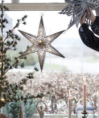 A gold star LED Christmas window display decoration made from tinsel and iron