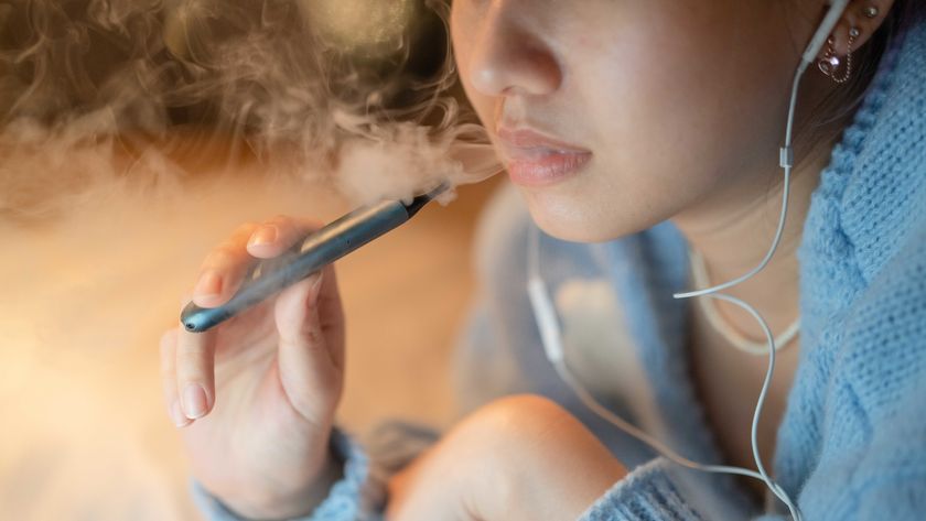 A woman vapes with a e-cigarette