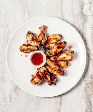 Chicken wings in white plate with chili sauce