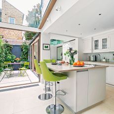 kitchen and dinning area with white interior white counter and green chairs