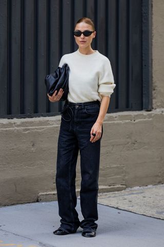 street style influencer wearing straight leg jeans and a fine knit jumper
