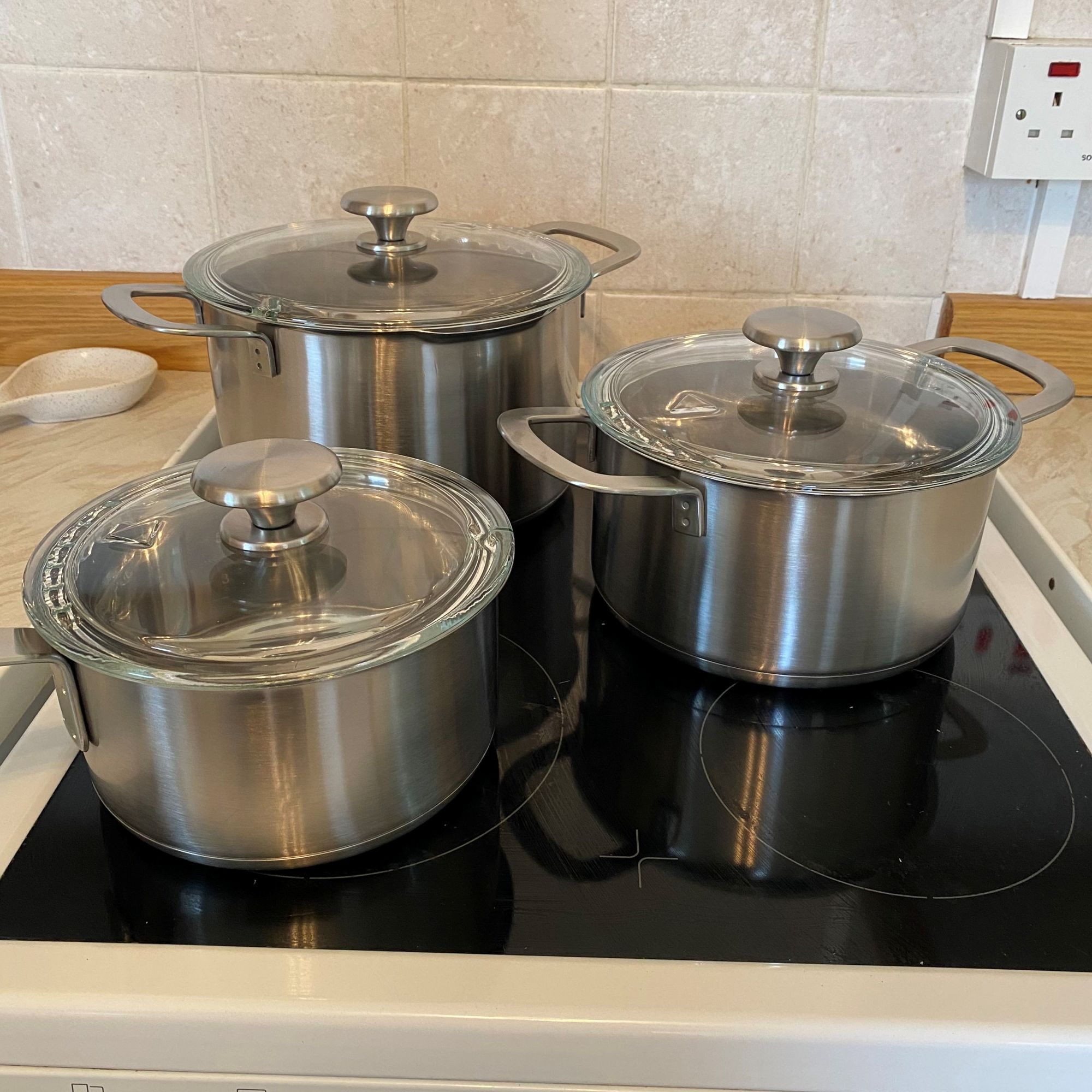 Saucepans from IKEA cookware set on hob