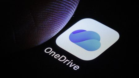 A thumb over the OneDrive logo on a phone
