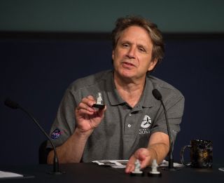 NASA’s Juno mission principal investigator Scott Bolton holds up one of the three Lego minifig-ures flying to Jupiter.