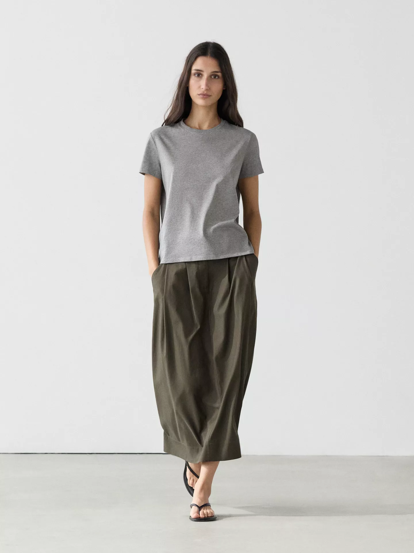 A model wears a grey Massimo Dutti t-shirt.