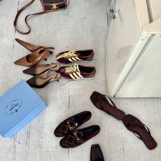 A scattered assortment of chic footwear, including on-trend women's Adidas sneakers, The Row and Sam Edelman slingback heels, Toteme flip-flops, and suede Gucci loafers.