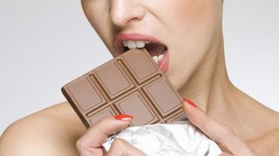 a woman eating a chocolate bar