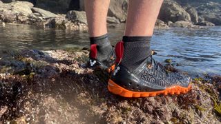 Water shoes vs water socks: A pair of water shoes standing by a lake