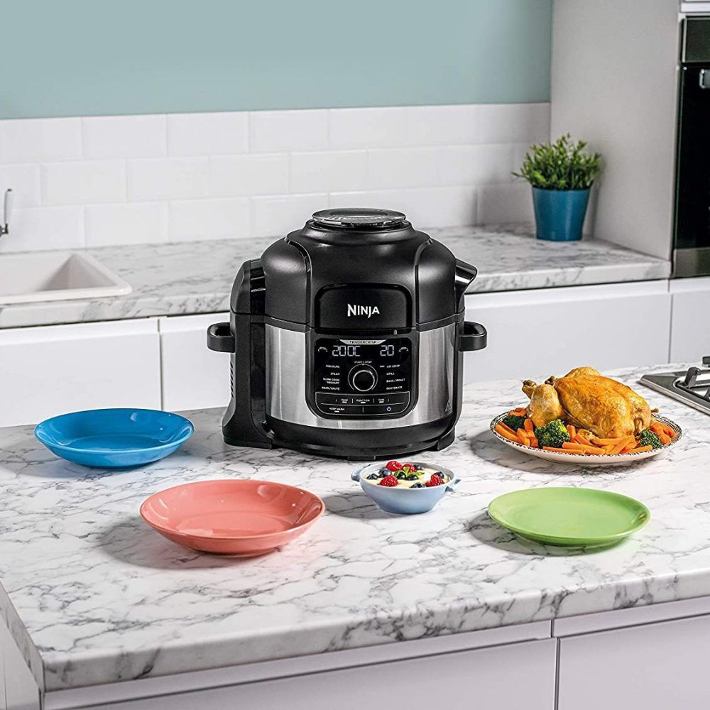 Ninja Foodi 9-in-1 Multi-Cooker on marble counter tops behind multi-coloured dinner bowls