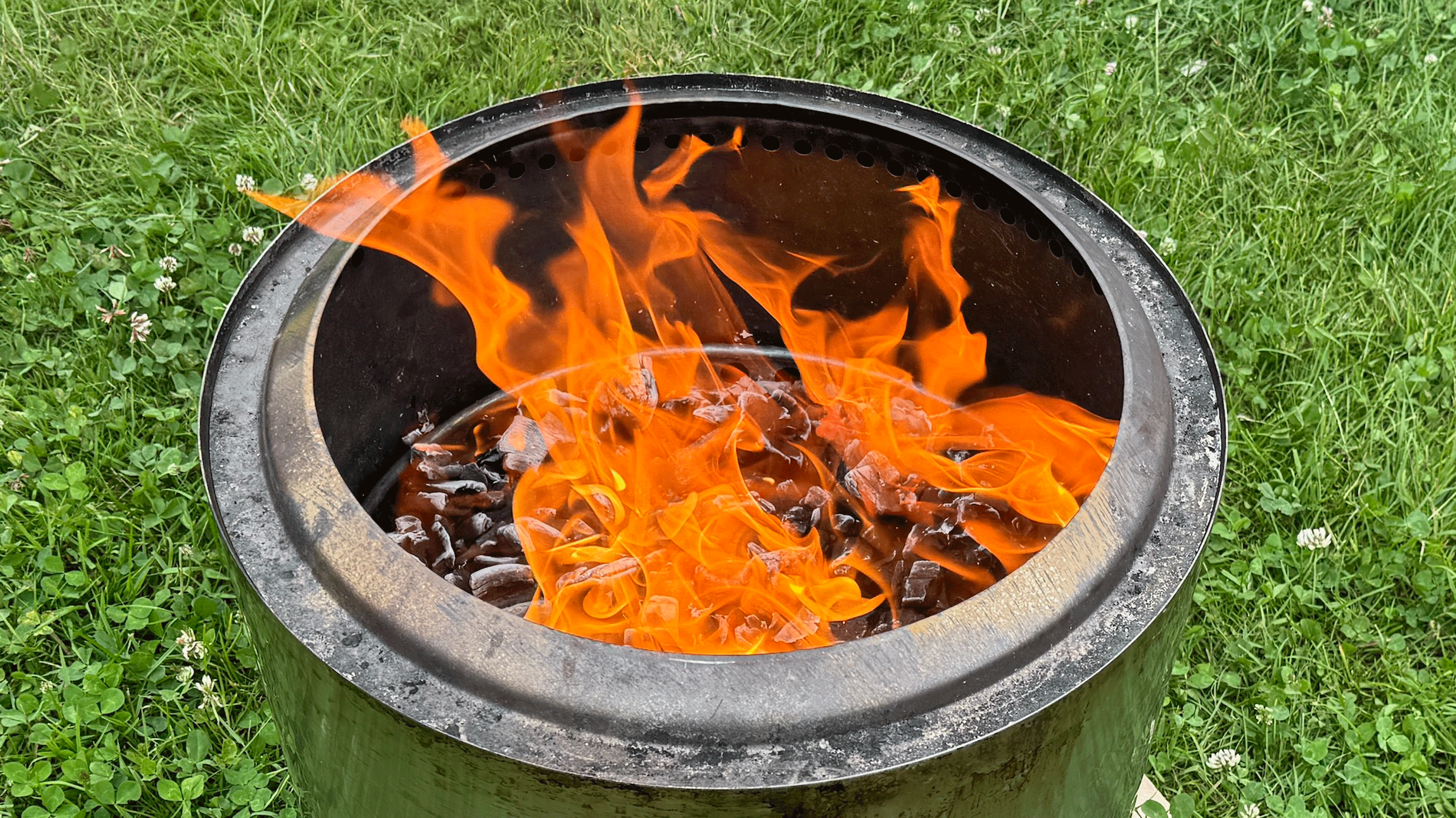Solo stove burning on a green lawn