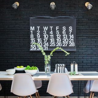 Black dining room with table and oversized calendar