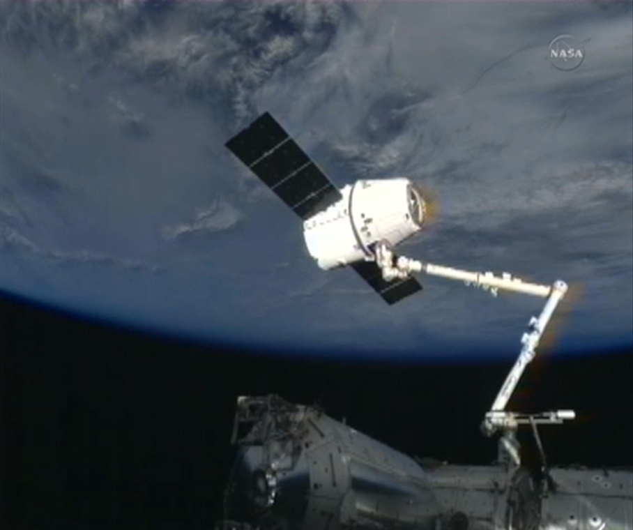 Dragon space capsule at the end of the International Space Station&#039;s robotic arm.