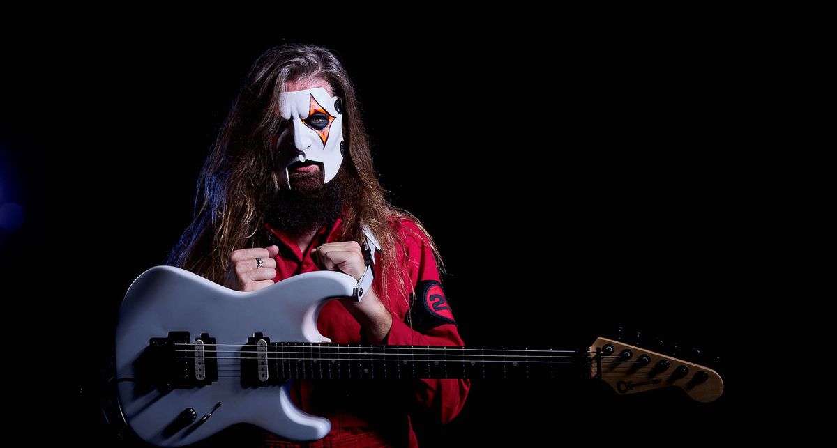 A portrait of a masked Jim Root with his signature white Charvel S-style