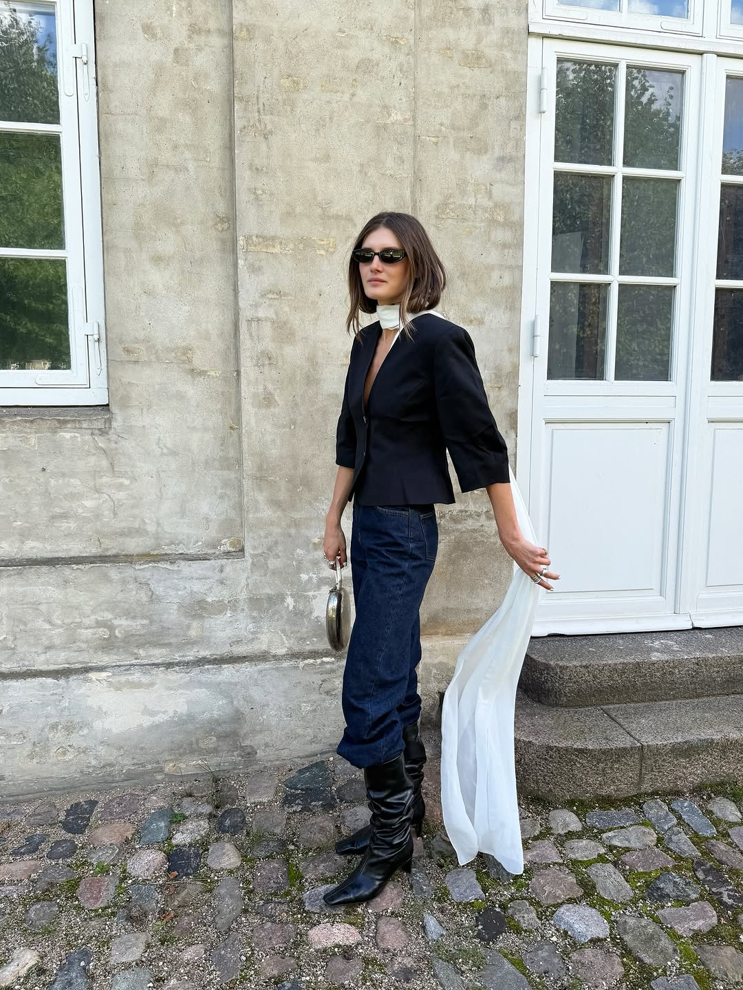 Woman wearing boots tucked into jeans trend fall 2025.