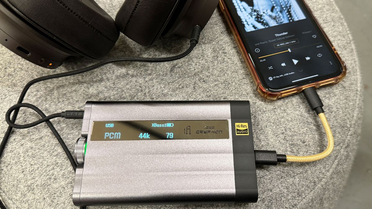 The iFi xDSD Gryphon next to a phone and heardphones