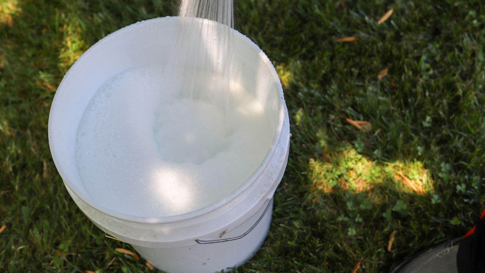picture of person filling bucket up with cleaning solution and water