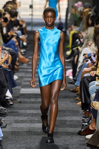 Model JW Anderson lief bei der Frühjahr/Sommer-Show 2025 in einem leuchtend blauen Minikleid.