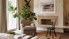 neutral living room with gray armchair and marble fireplace