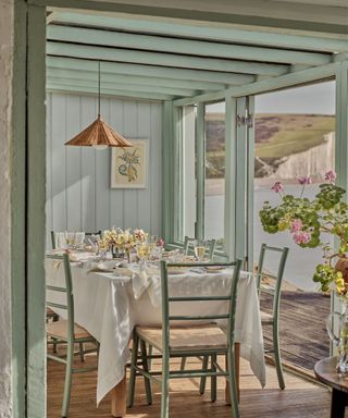 dining area painted in aqua with a view of the ocean and the coastline