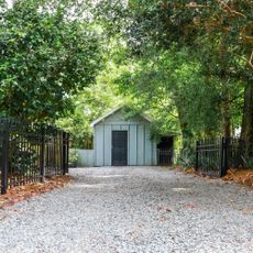 gravel driveway with shed and fence