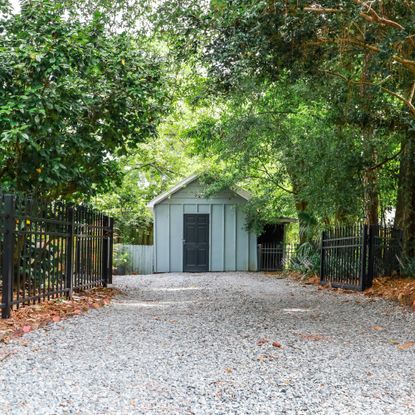 gravel driveway with shed and fence