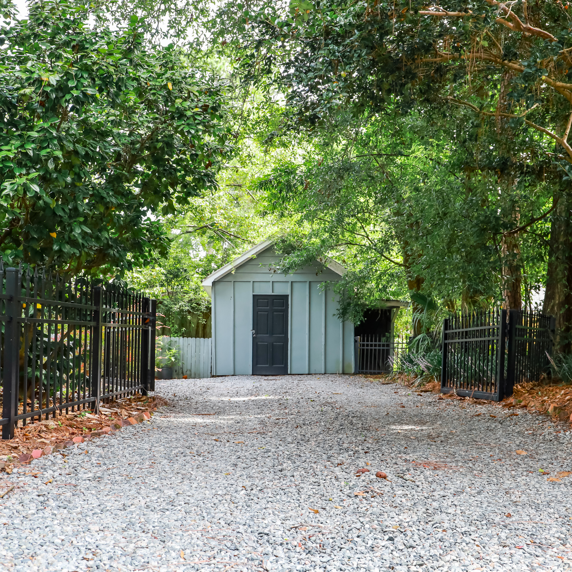 gravel driveway with shed and fence