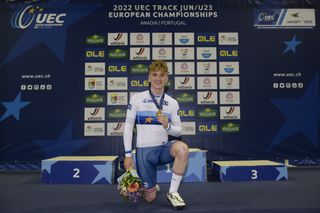 Ben Wiggins shows off his gold medal from the points race at the junior European Championships in 2022