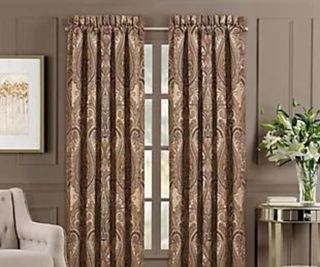 Patterned curtains against a brown wall.