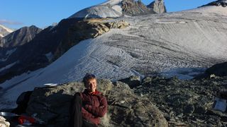 Man wearing an Artilect M-Divide Fusion Stretch Hoodie in the Alps