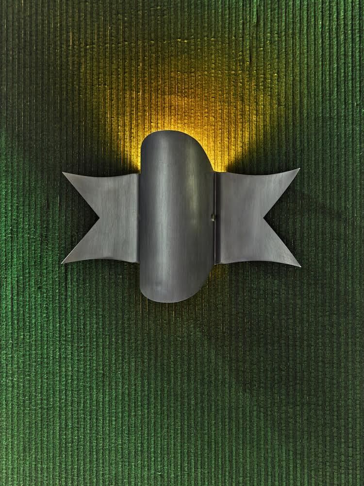 ‘Banner’, a metal sconce inspired by the ribbons depicted in classic 1930s and 1940s military tattoos, and a tribute to the works of Maria Pergay