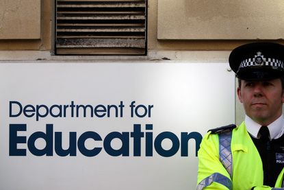 LONDON, ENGLAND - MARCH 28:(L-R) A policeman guards the Department for Education as teaching staff demonstrate outside on March 28, 2012 in London, England. London Based teachers marched to p