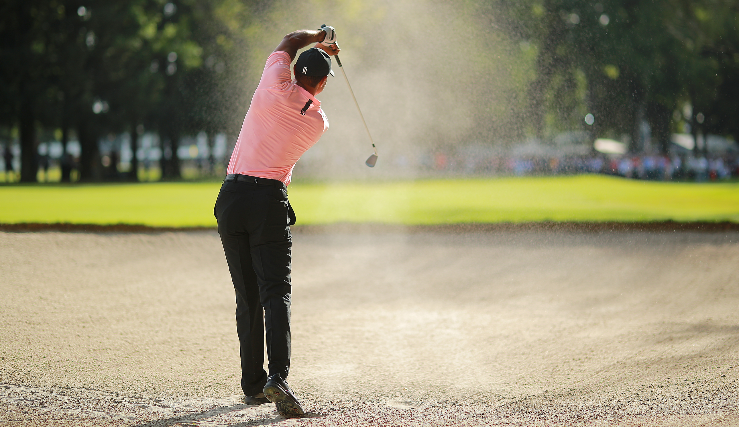 Tiger Woods hits a bunker shot