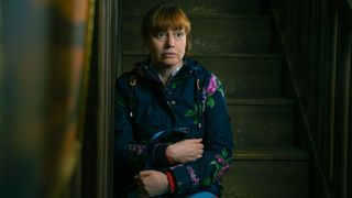 Emmerdale character Lydia Dingle, played by Karen Blick, looking upset sitting on the stairs alone 