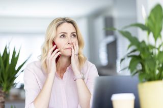 Businesswoman talking on smart phone at home office