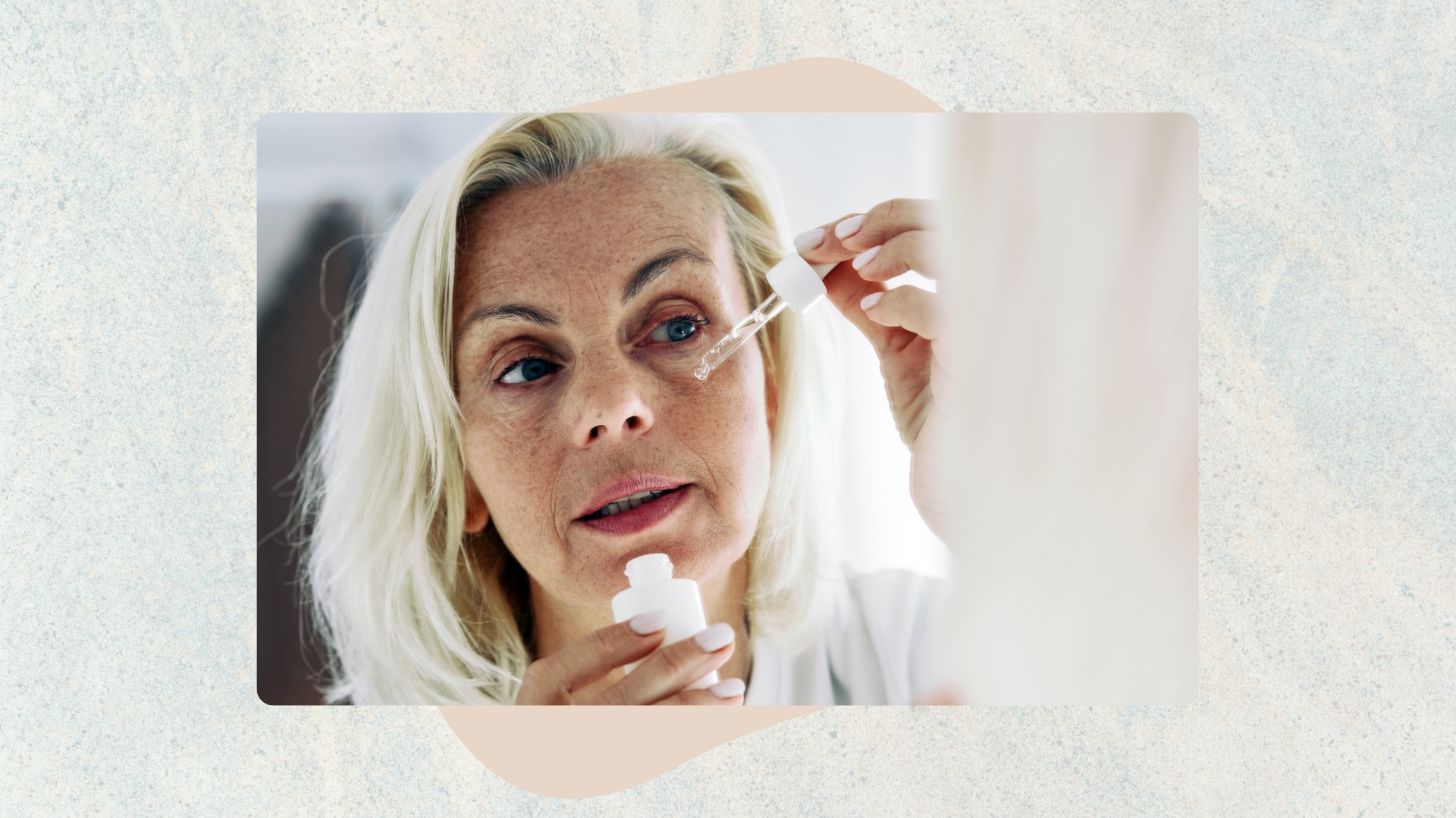 Image of woman with white hair applying serum to face, on a blue textured background 