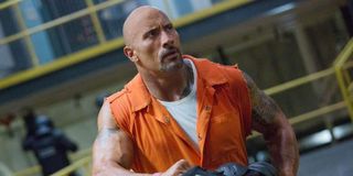 Luke Hobbs (Dwayne Johnson) wears a cut-off orange jumpsuit in prison in 'Hobbs and Shaw.'
