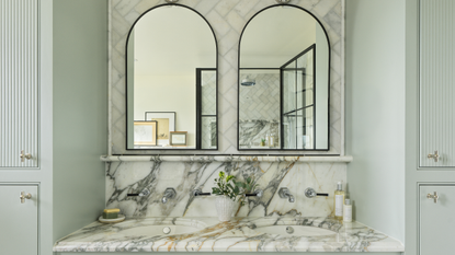 double sink with marble counter and tiled backsplash