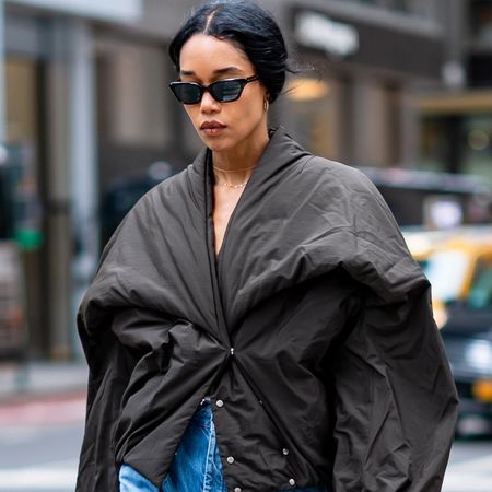 Laura Harrier wearing a puffer jacket, barrel-leg jeans, and burgundy patent leather heels in New York City. 