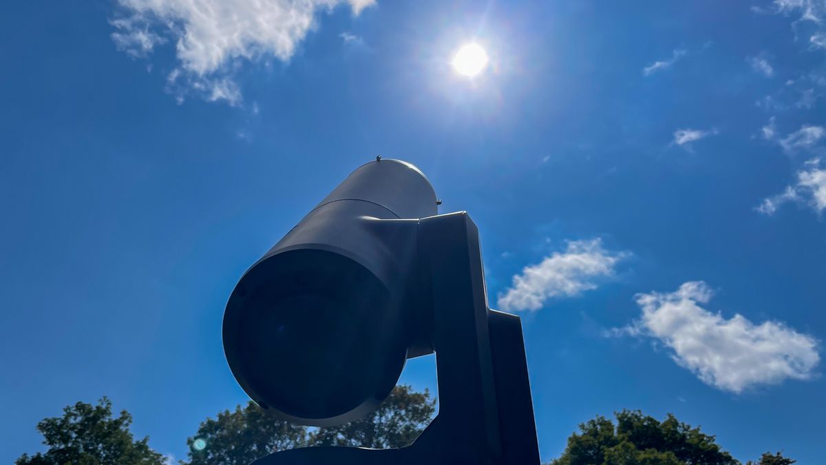 A Unistellar eVscope 2 pointing at the sun in the blue sky.